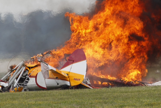 Flames erupt from a plane after it crashed at the Vectren Air Show at the airport in Dayton, Ohio. The crash killed the pilot and stunt walker on the plane instantly, authorities said.