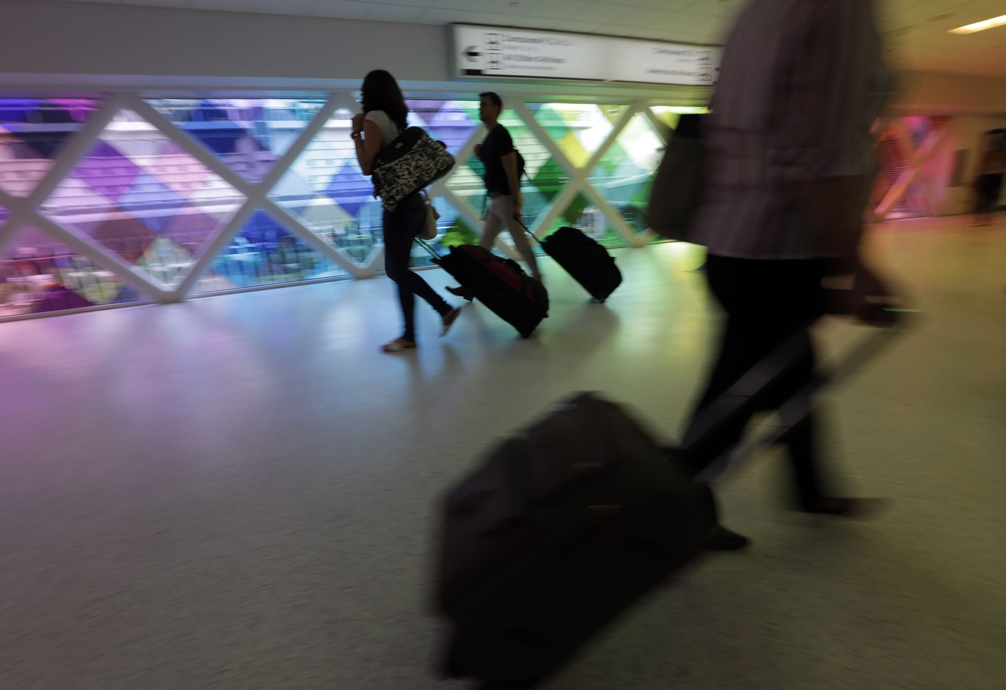 Passengers walk through an airport in Miami.
