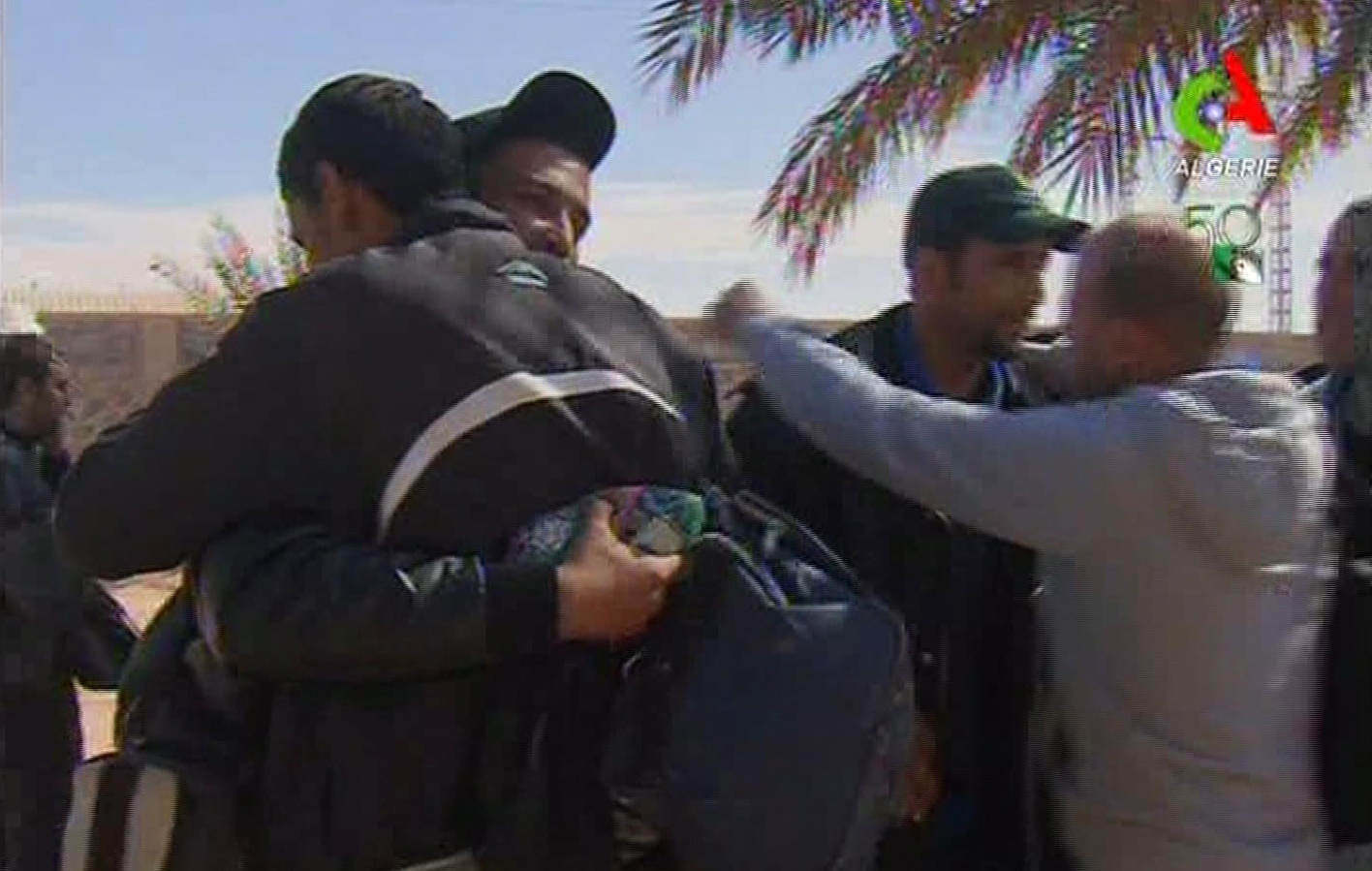 Rescued hostages hug each other in Ain Amenas, Algeria, in this image taken from television Friday. Algeria's state news service says nearly 100 out of 132 foreign hostages have been freed from a gas plant where Islamist militants had held them captive for three days.