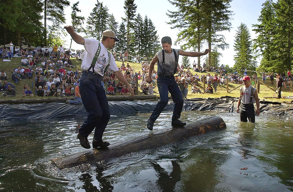 Cliff Campbell, left, and Greg Brown, both of Amboy, compete in the log roll event during a recent Territorial Days logging show.