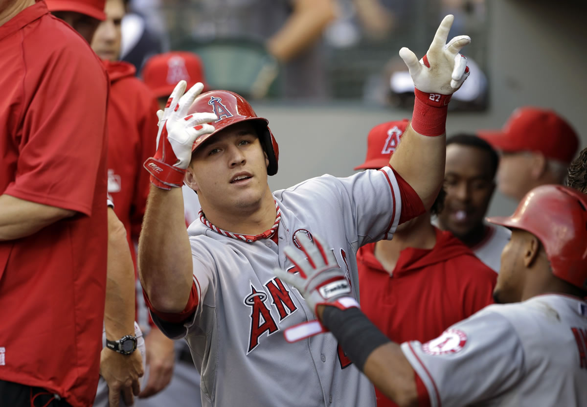 Los Angeles Angels' Mike Trout motions in the dugout after hitting a two-run home run against the Seattle Mariners in the first inning Saturday.