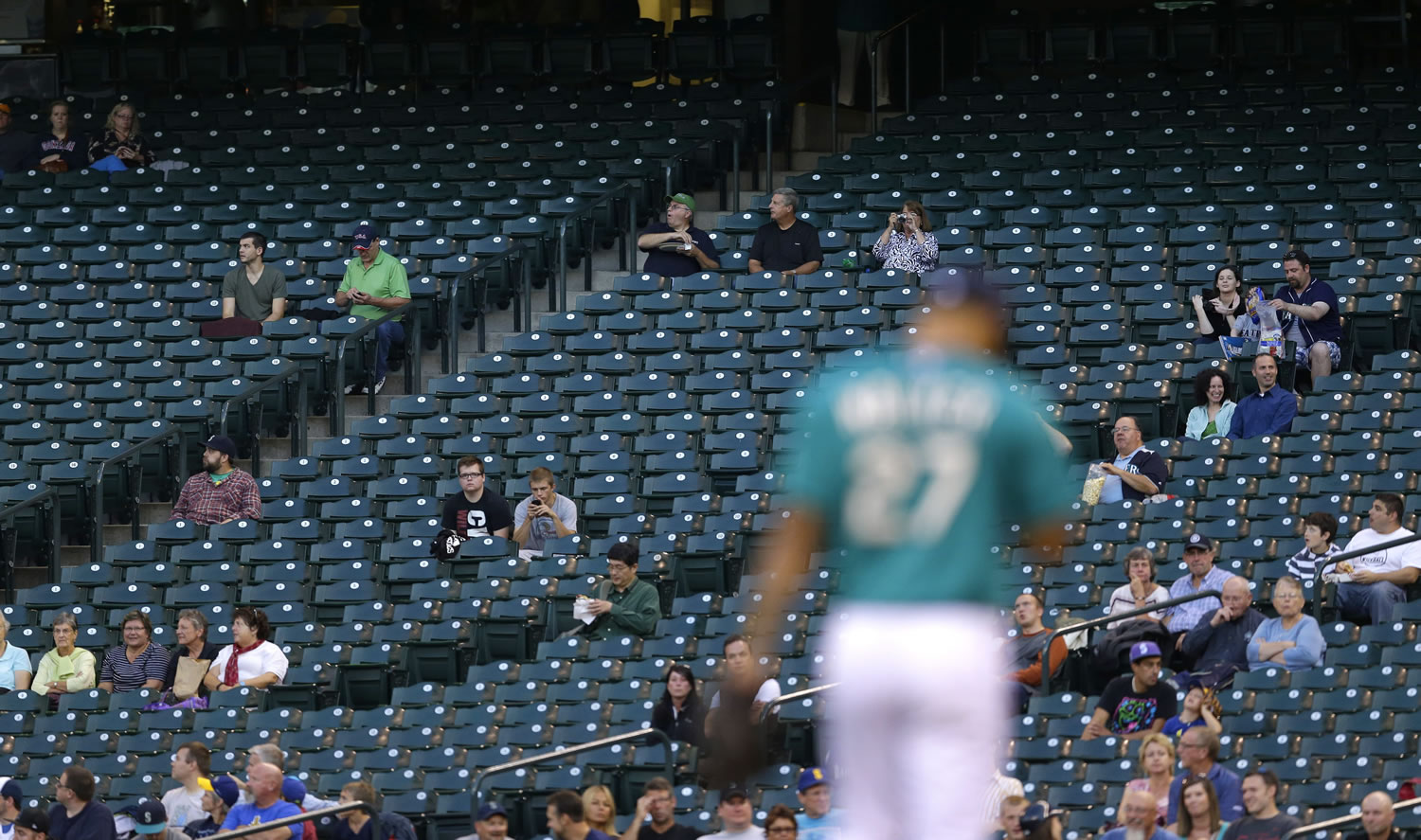 Only a few fans are in the stands near first base at Safeco Field as Seattle Mariners starting pitcher Taijuan Walker takes the mound for Monday's game against the Houston Astros.