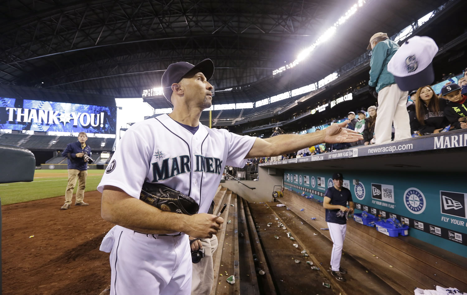 Seattle Mariners outfielder Raul Ibanez tosses a cap he autographed back to a fan after the Mariners' final game of the season Sunday at Safeco Field.