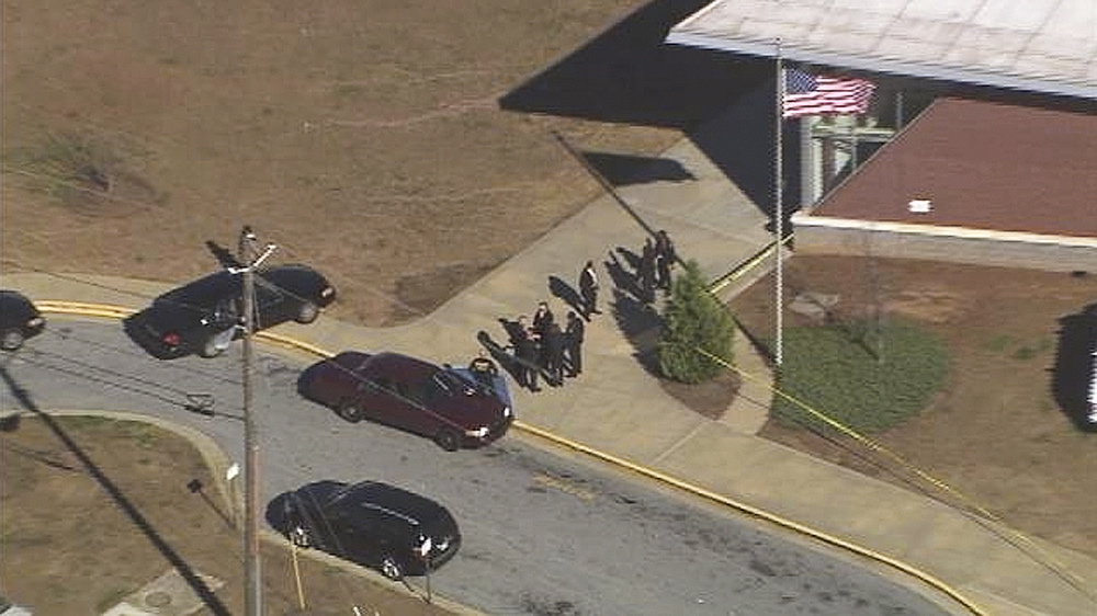 In this image made from video and released by WSB-TV, authorities investigate the scene of a school shooting Thursday in Atlanta. Authorities say a 14-year-old has been wounded in a shooting at an Atlanta middle school and a suspect has been taken into custody.