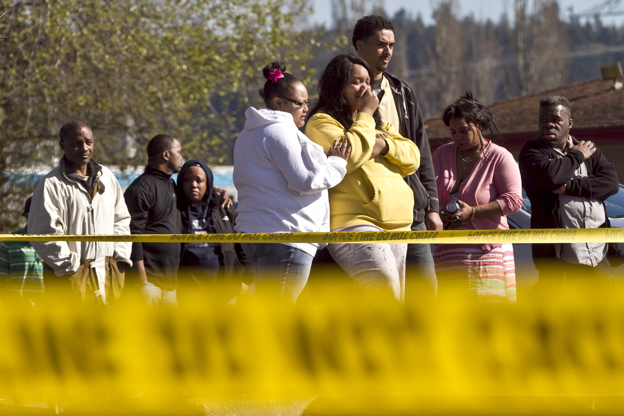 Family members of a victim mourn outside The Sports Page bar in Auburn on Easter Sunday as police investigate the scene of a shooting that killed three men and wounded another.
