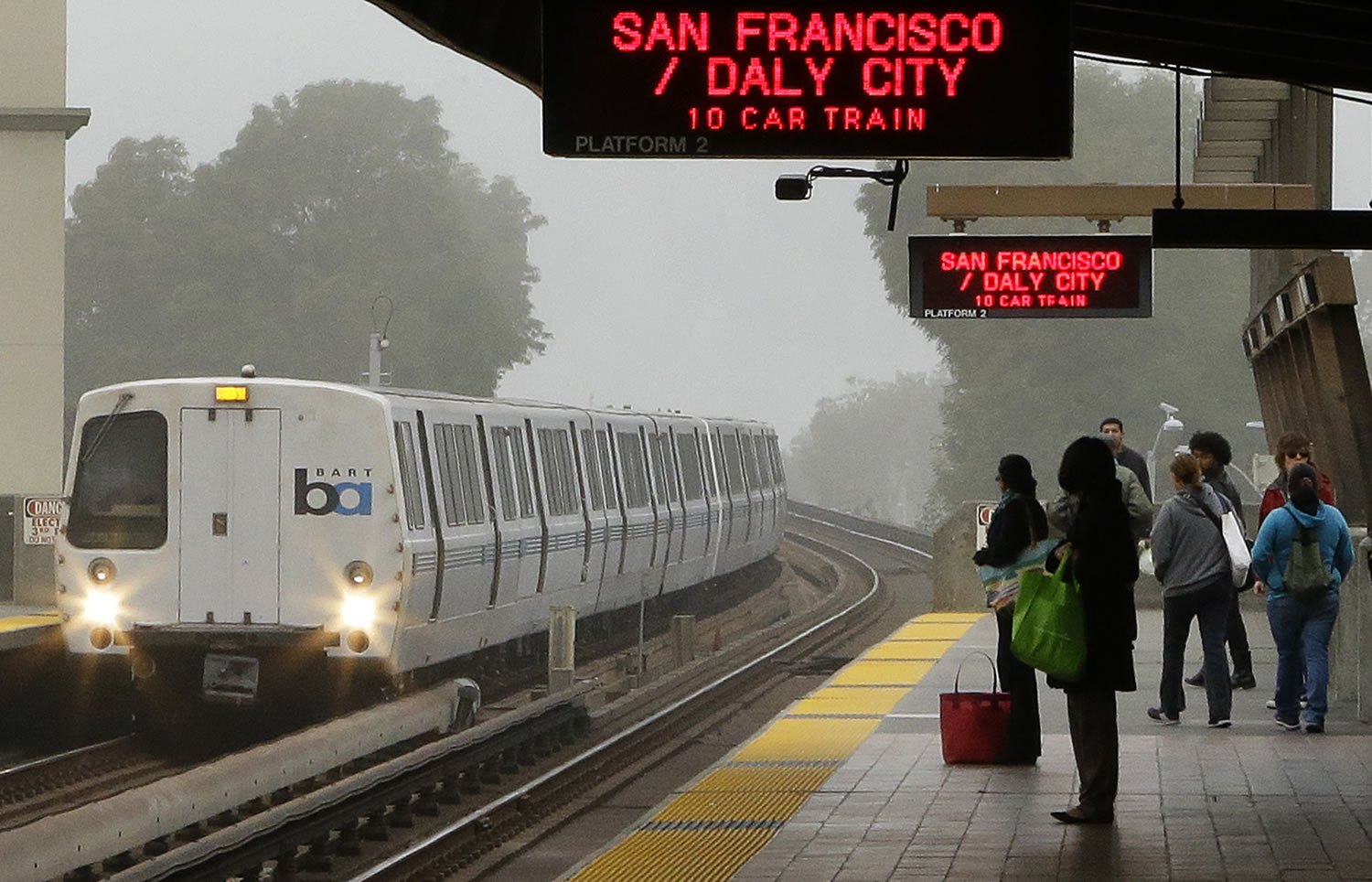 Passengers wait for a Bay Area Rapid Transit train Tuesday in Oakland, Calif.