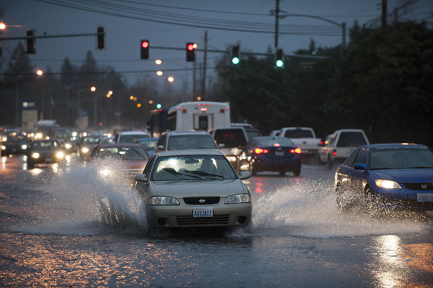 A motorist navigates through standing water at Mill Plain Boulevard and Lieser Road on Tuesday afternoon.