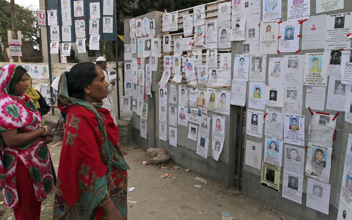 Bangladeshi women look at portraits of missing persons on a wall of a school turned into a makeshift morgue near the site of a building that collapsed in Savar, near Dhaka, Bangladesh, on Wednesday.