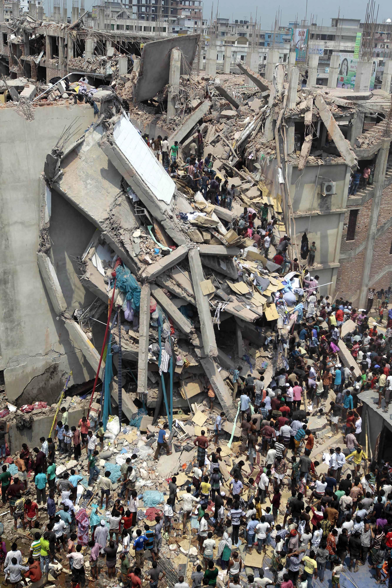 People and rescuers gather after an eight-story building housing several garment factories collapsed in Savar, near Dhaka, Bangladesh, on Wednesday.