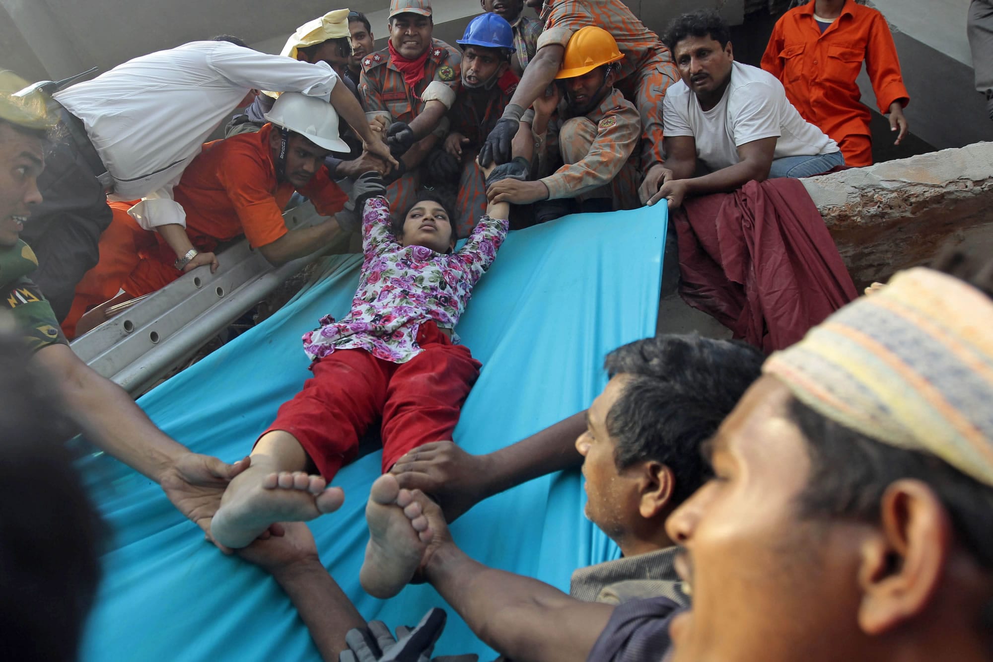 Rescuers lower down a survivor from the debris of a building that collapsed in Savar, near Dhaka, Bangladesh, on Wednesday. An eight-storey building housing several garment factories collapsed near Bangladeshis capital on Wednesday, killing dozens of people and trapping many more under a jumbled mess of concrete.
