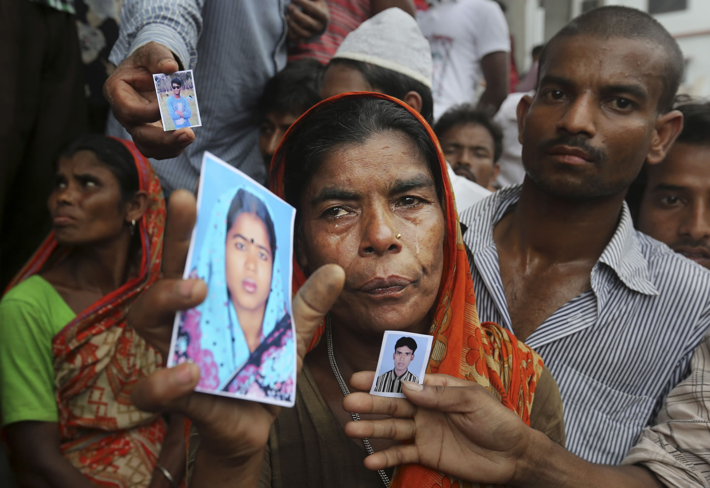 A Bangladeshi weeps as she holds a picture of a missing relative Thursday at the site of a building that collapsed Wednesday in Savar, near Dhaka, Bangladesh.