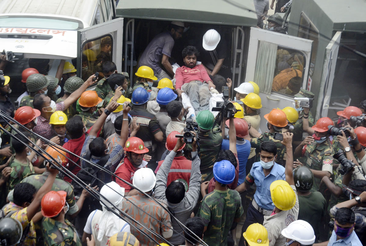 A survivor is carried into an ambulance Sunday, while surrounded by onlookers, after being rescued from the garment factory building that collapsed Wednesday in Savar, near Dhaka, Bangladesh.