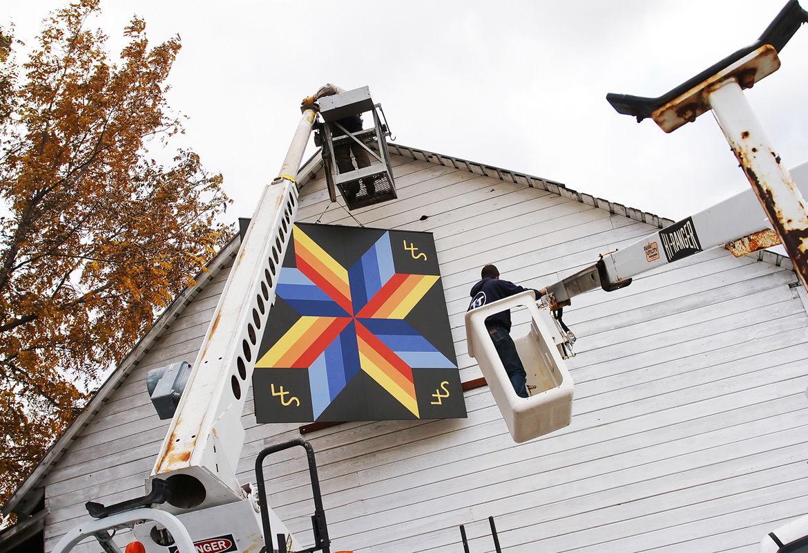 Photos by Brian Myrick/The Daily Record
Barn owner Randy Grant, top, and Tommy Wilmart, with T&amp;T Electric, work to install an 8' x 8' barn quilt on a barn at the Yakima River RV park in Ellensburg last month.