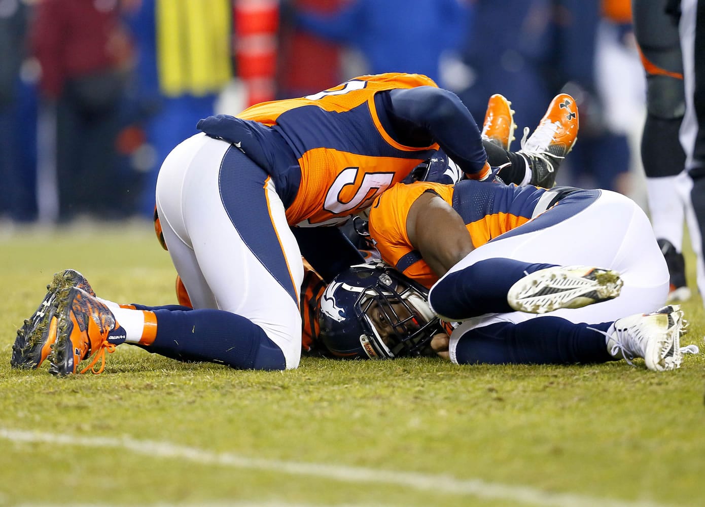 Denver Broncos outside linebacker DeMarcus Ware, right, lies on his fumble recovery for the win after an NFL football game against the Cincinnati Bengals, Monday, Dec. 28, 2015, in Denver. The Broncos won 20-17 in overtime. At left is Denver Broncos inside linebacker Danny Trevathan.
