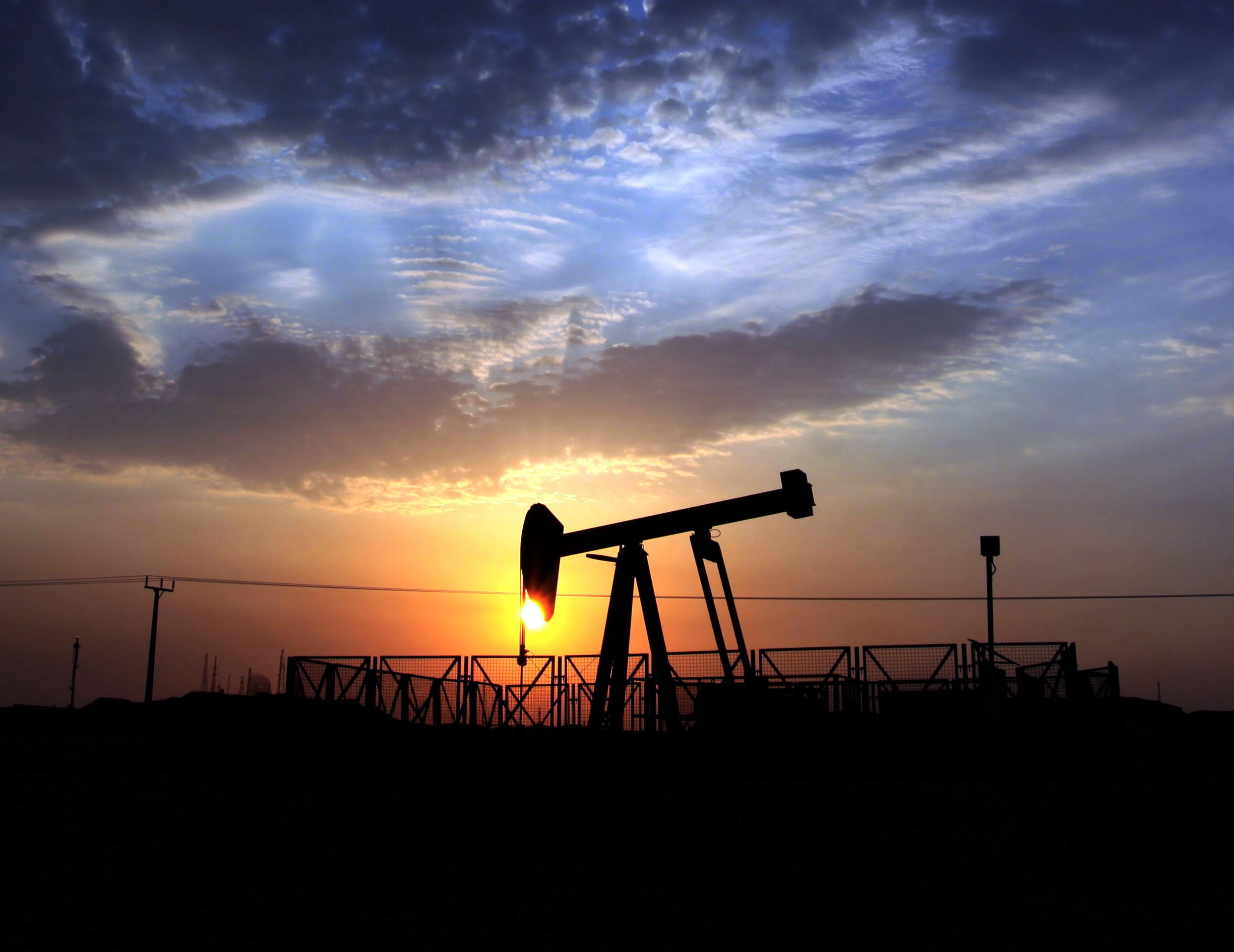 An oil pump operates in the desert oil fields of Sakhir, Bahrain, at sunset. New troves of oil are being found all over the globe and each barrel produced is selling for about $100, as of Thursday. But profits and production at the worldis biggest oil companies are slumping badly.