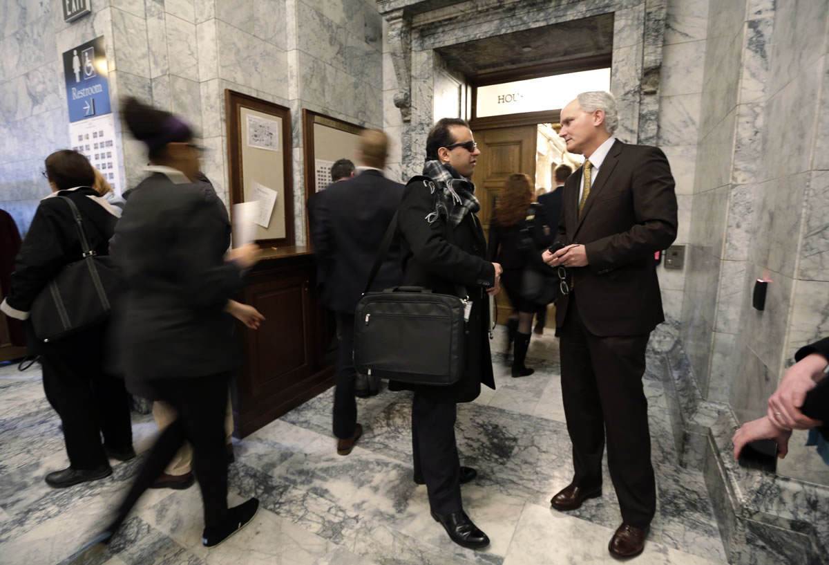 In this Feb. 20 photo, Rep. Cyrus Habib, D-Kirkland, speaks with lobbyist Jim Richards, right, outside the House chambers in Olympia.