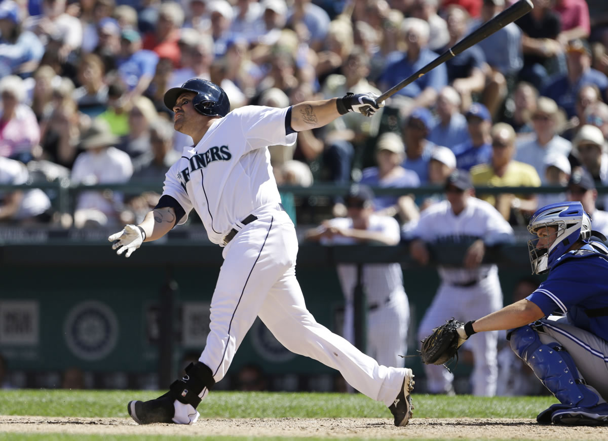 Seattle Mariners' Humberto Quintero, left, watches the path of his two-run home run with Toronto Blue Jays catcher DeMarlo Hale in the fifth inning of a baseball game on Wednesday, Aug. 7, 2013, in Seattle.