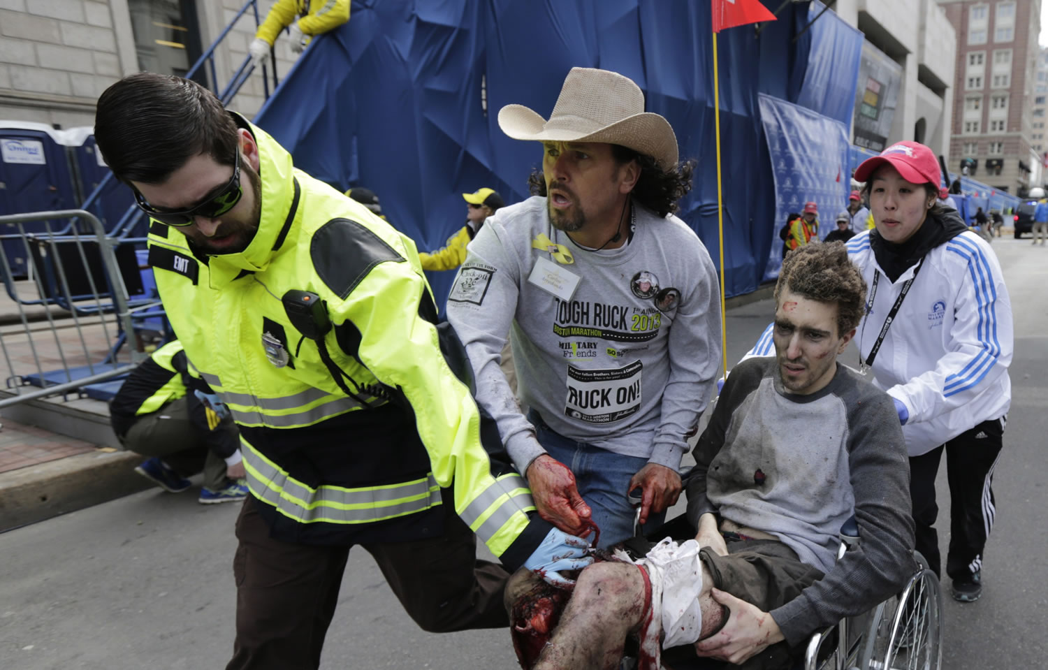 Medical responders run bombing victim Jeff Bauman past the finish line of the 2013 Boston Marathon following one of the explosions Monday in Boston.