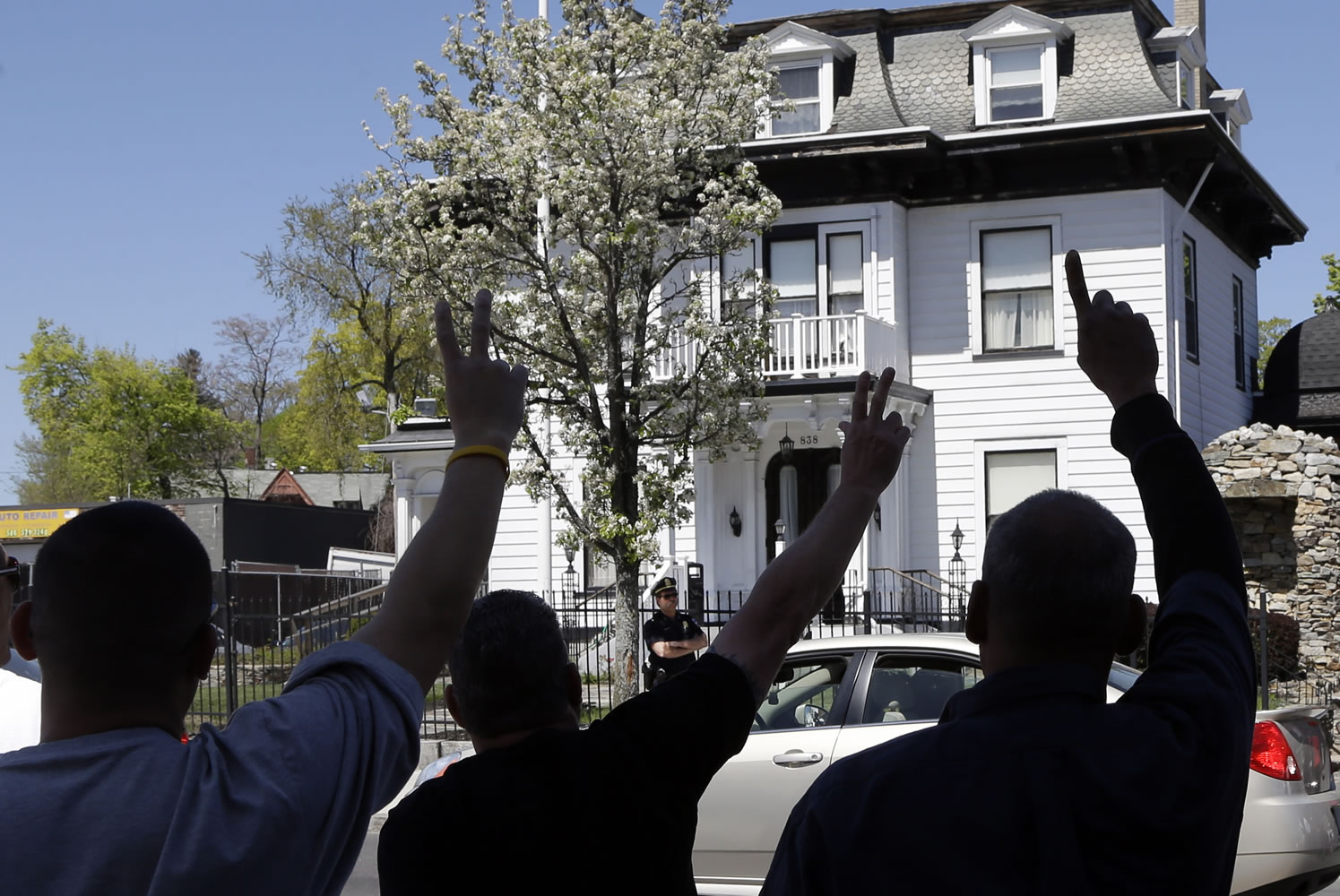 Protesters gesture outside the Graham, Putnam, and Mahoney Funeral Parlor in Worcester, Mass., on Monday where the body of killed Boston Marathon bombing suspect Tamerlan Tsarnaev is being prepared for burial.
