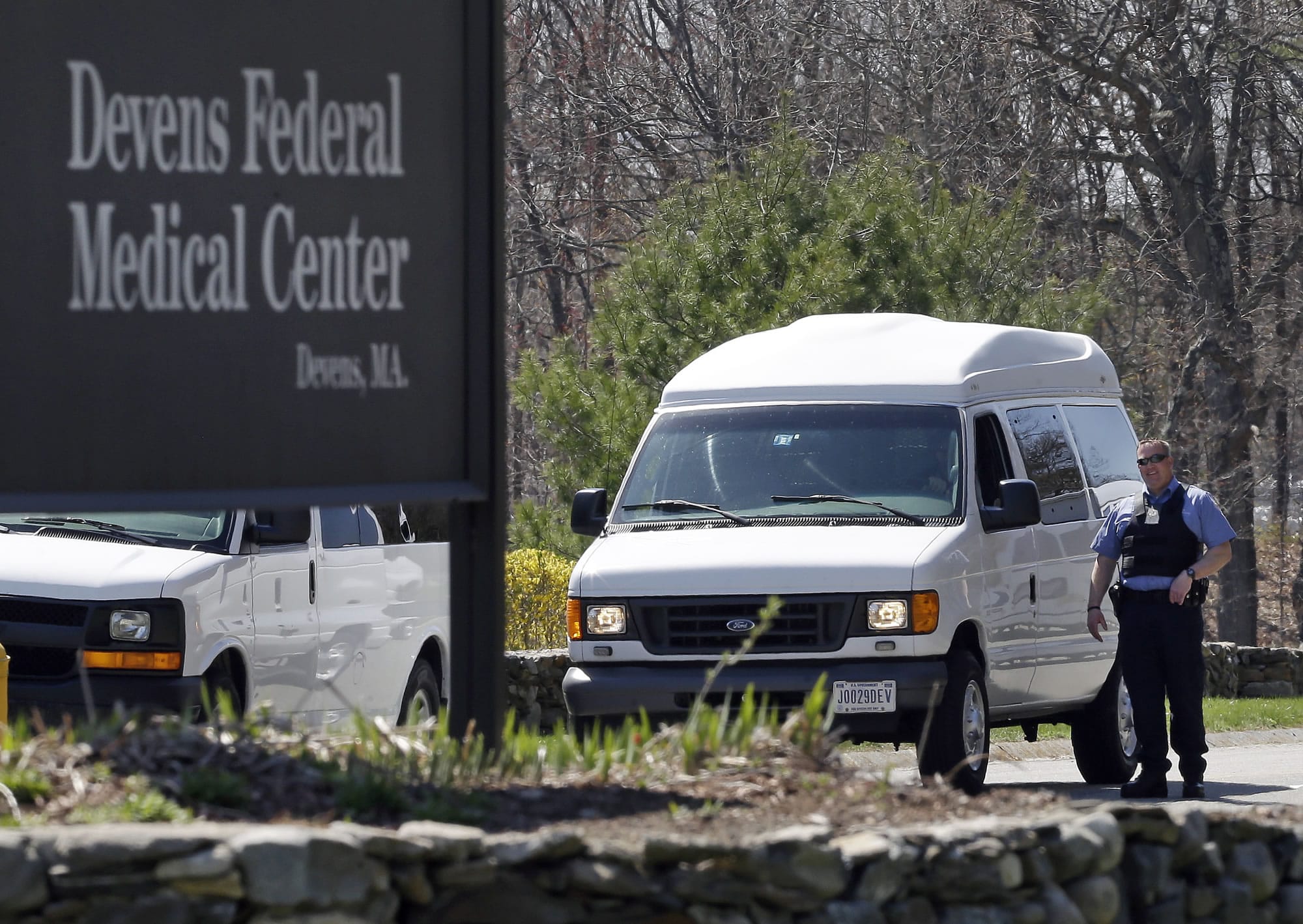 A guard stands near the entrance to the Devens Federal Medical Center in Devens, Mass., on Friday. The U.S.