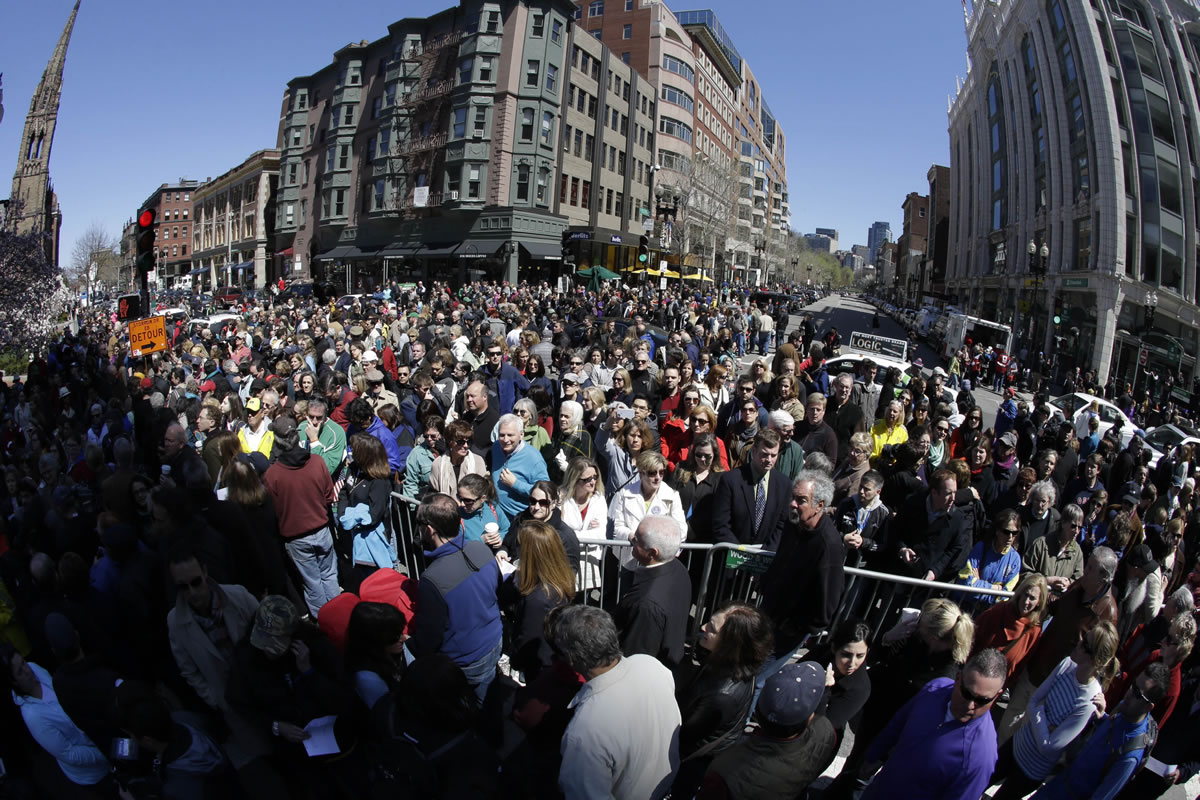 In this photograph made with a fisheye lens, people attend an interfaith service held Sunday near a makeshift memorial on Boylston Street, near the finish line of the Boston Marathon in Boston.