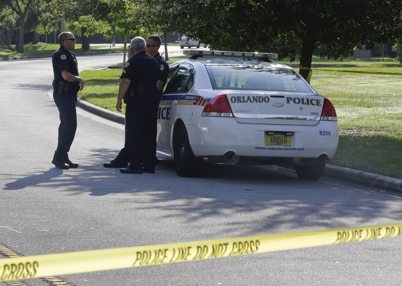 Police officers block the entrance to an apartment complex where a man was fatally shot Wednesday in Orlando, Fla.