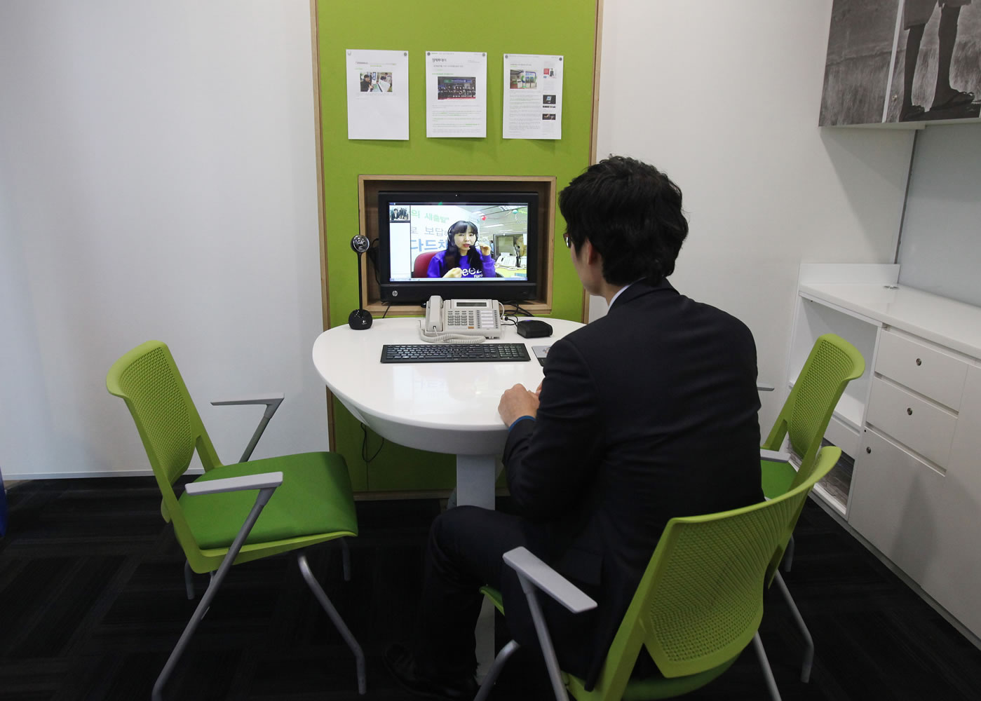 Customer Chung Yong-min does her banking through a screen monitor connected to a video conference with bank employee Oh Ji-young, located in another office, at a Smart Banking Center in Seoul, South Korea.