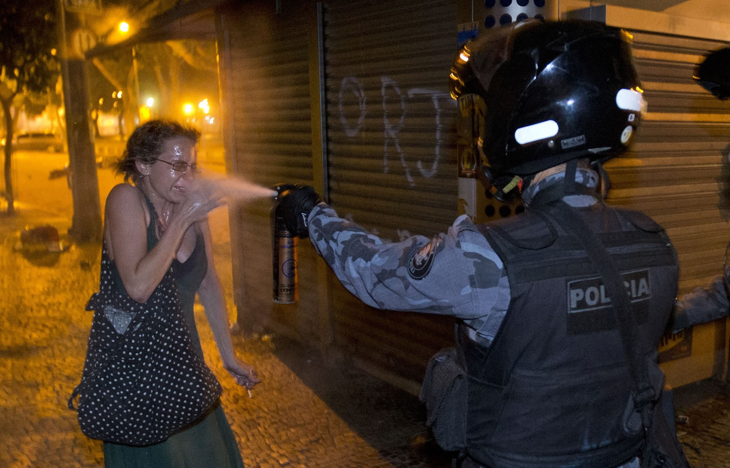 A military policeman pepper sprays a protester during a demonstration in Rio de Janeiro on Monday.