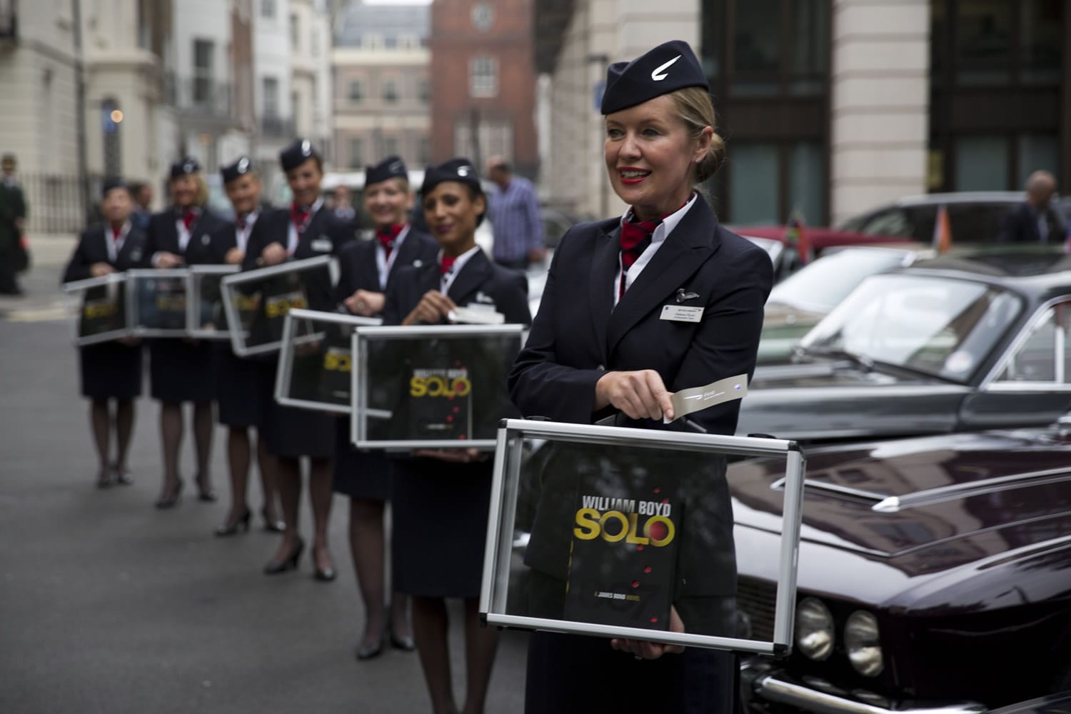 Flight attendants pose for photographers with copies of the new James Bond novel &quot;Solo&quot; during a launch photocall outside the Dorchester Hotel in London on Wednesday.