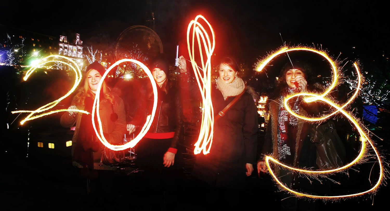 Katy Saunders, left, Alex Mueller, center left, Rebekka Frank and Arina Motamedi, right, play with sparklers ahead of welcoming in the new year during the 2013 Edinburgh Hogmanay celebrations, Scotland, Monday December 31, 2012. See PA story SOCIAL NewYear.