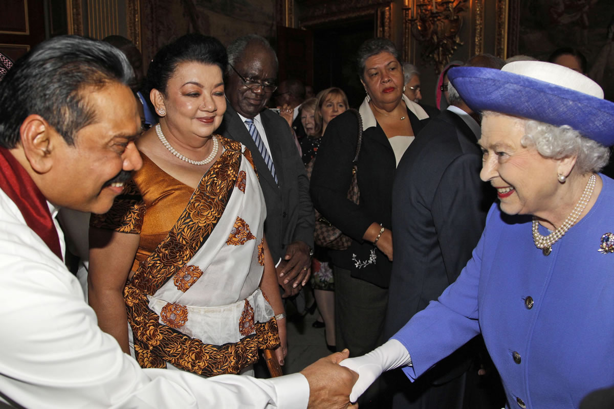 Britain's Queen Elizabeth II, right, as she shakes hands with Sri Lanka President Mahinda Rajapaksa, left, as his wife Shiranthi Rajapaksa, center, looks on, during a reception prior to a lunch with Commonwealth Nations Heads  of Government and representatives of the Commonwealth nations in central London in 2012. Queen Elizabeth II will skip the Commonwealth heads of government meeting in Sri Lanka later this year -- the first time she's missed the biennial gathering since 1971, Buckingham Palace said Tuesday.