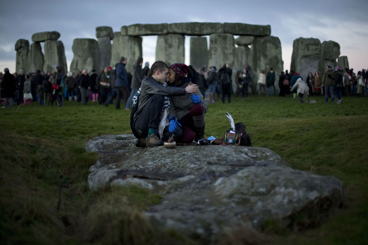 People embrace by the ancient stone circle of Stonehenge, in southern England, in December 2012.