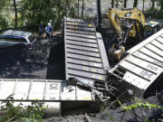 FILE -In this Tuesday, Aug. 21, 2012, file photo, officials, top left, inspect part of a CSX freight train that derailed alongside a parking lot overnight in Ellicott City, Md. A little-known truth about North American railroads: No rules govern when rail becomes too worn down. Since 2000, U.S. officials blamed rail wear as the direct cause of 111 derailments causing $11 million in damage.