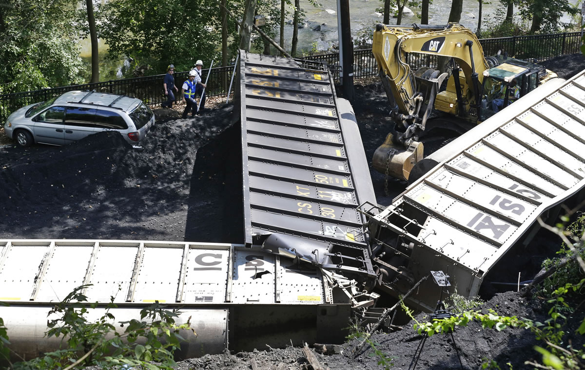 FILE -In this Tuesday, Aug. 21, 2012, file photo, officials, top left, inspect part of a CSX freight train that derailed alongside a parking lot overnight in Ellicott City, Md. A little-known truth about North American railroads: No rules govern when rail becomes too worn down. Since 2000, U.S. officials blamed rail wear as the direct cause of 111 derailments causing $11 million in damage.