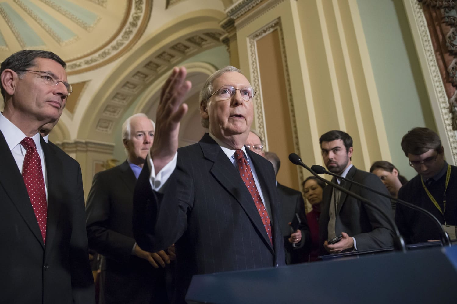 Senate Majority Leader Mitch McConnell, R-Ky., joined by Sen. John Barrasso, R-Wyo., far left, and Senate Majority Whip John Cornyn, R-Texas, left rear, talks to reporters about the Friday night deadline for funding the government, on Capitol Hill in Washington, Tuesday, Dec. 8, 2015. McConnell, the top Republican in the Senate, also dismissed remarks yesterday by GOP  presidential hopeful Donald Trump about restricting Muslim travel to the United States. McConnell, without mentioning Trump by name, said those remarks are  ?completely and totally inconsistent with American values.&quot;   (AP Photo/J.