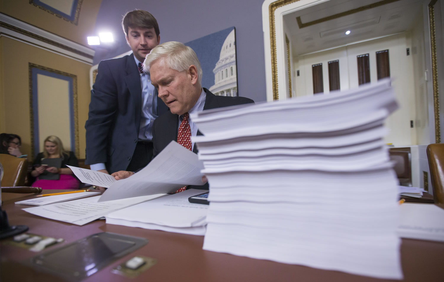 House Rules Committee Chairman Pete Sessions, R-Texas, examines a printout of the $1.1 trillion spending bill Wednesday at the Capitol. President Barack Obama is expected to sign the legislation. (J.