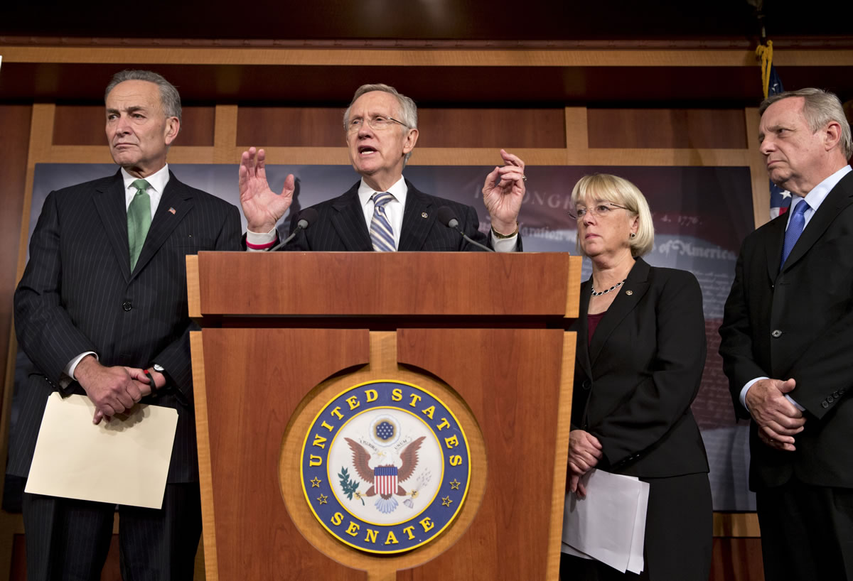 Senate Majority Leader Harry Reid, D-Nev., and Democratic leaders speak with reporters after voting on a measure to avert a threatened Treasury default and reopen the government after a partial, 16-day shutdown at the Capitol in Washington on Wednesday, as Sen. Chuck Schumer, D-N.Y., Senate Majority Leader Harry Reid, D-Nev., Sen.