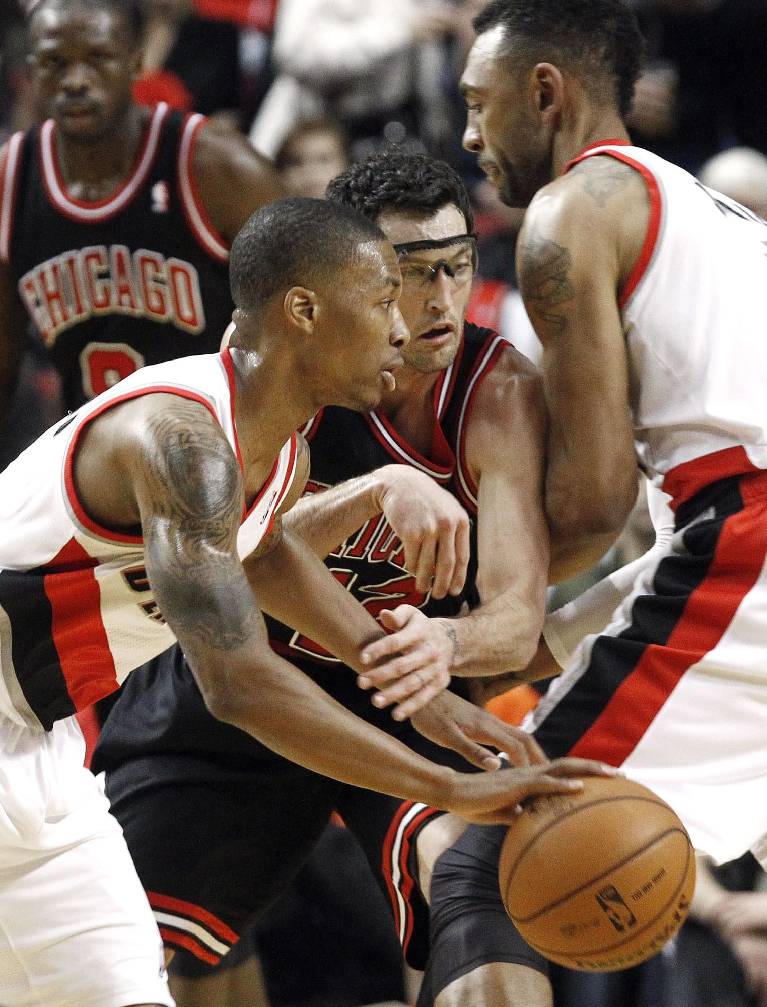 Portland Trail Blazers guard Damian Lillard, left, drives on Chicago Bulls guard Kirk Hinrich, middle, as he is screened out by Trail Blazers forward Jared Jeffries during the first quarter Sunday.