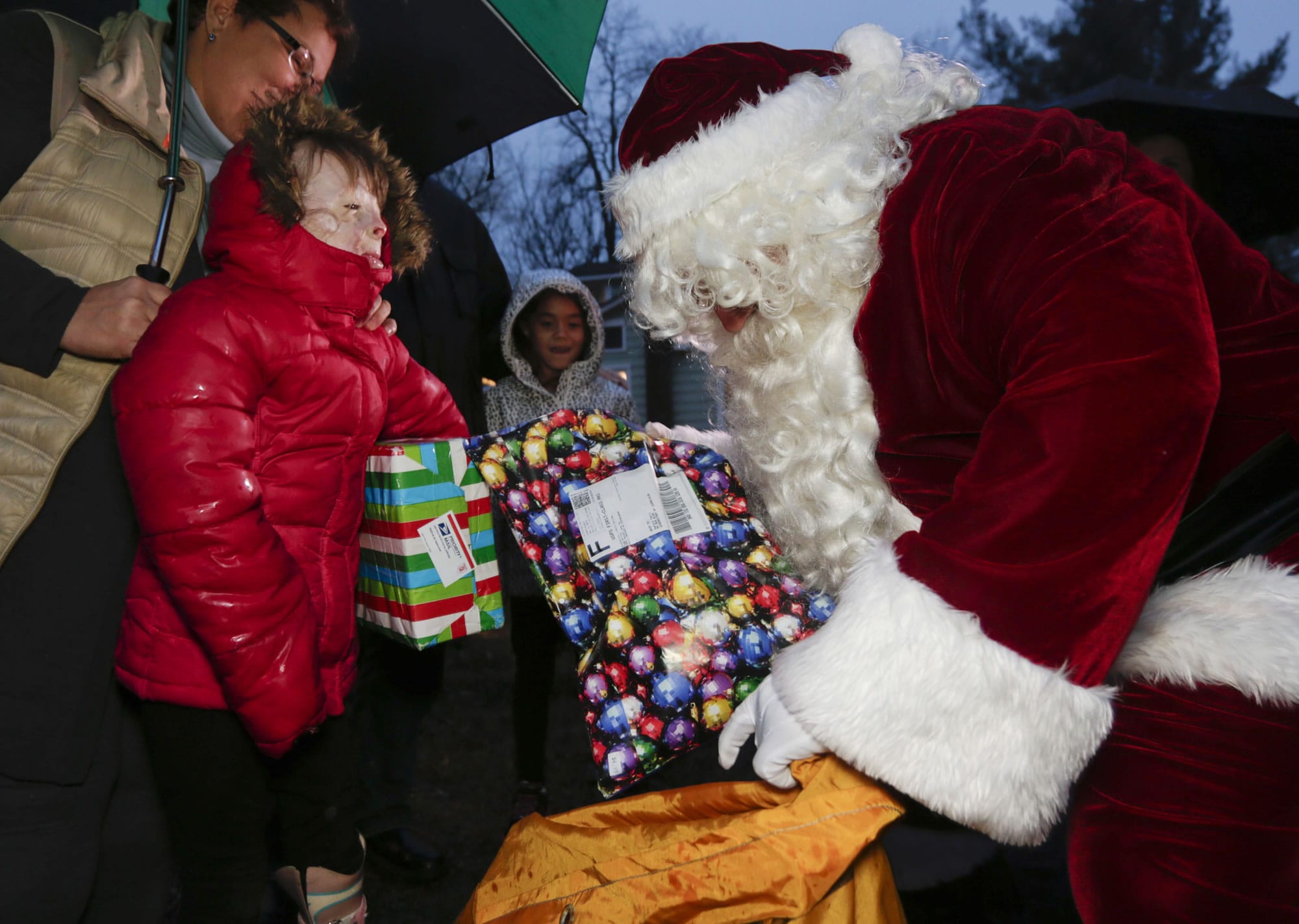 Safyre Terry, 8, receives packages from Santa Claus in Rotterdam, N.Y., on Dec. 17. Terry Lost her father and siblings in an arson fire that left her severely scarred.