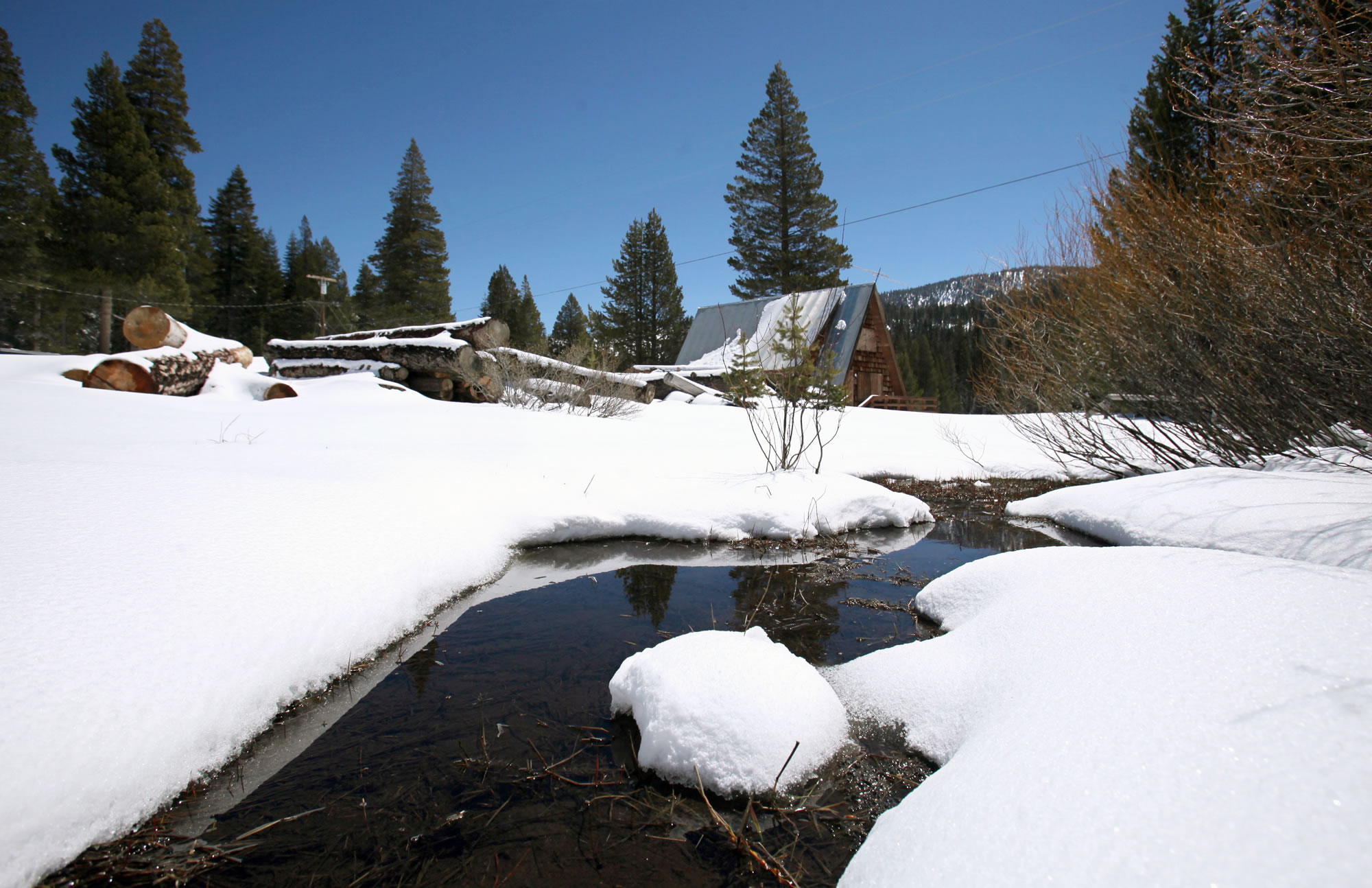 A stream seen running through snow covered banks near the site of the Department of Water Resources snow survey at Echo Summit, Calif. on April 30,2010. A new report released Thursday found climate change is affecting California.