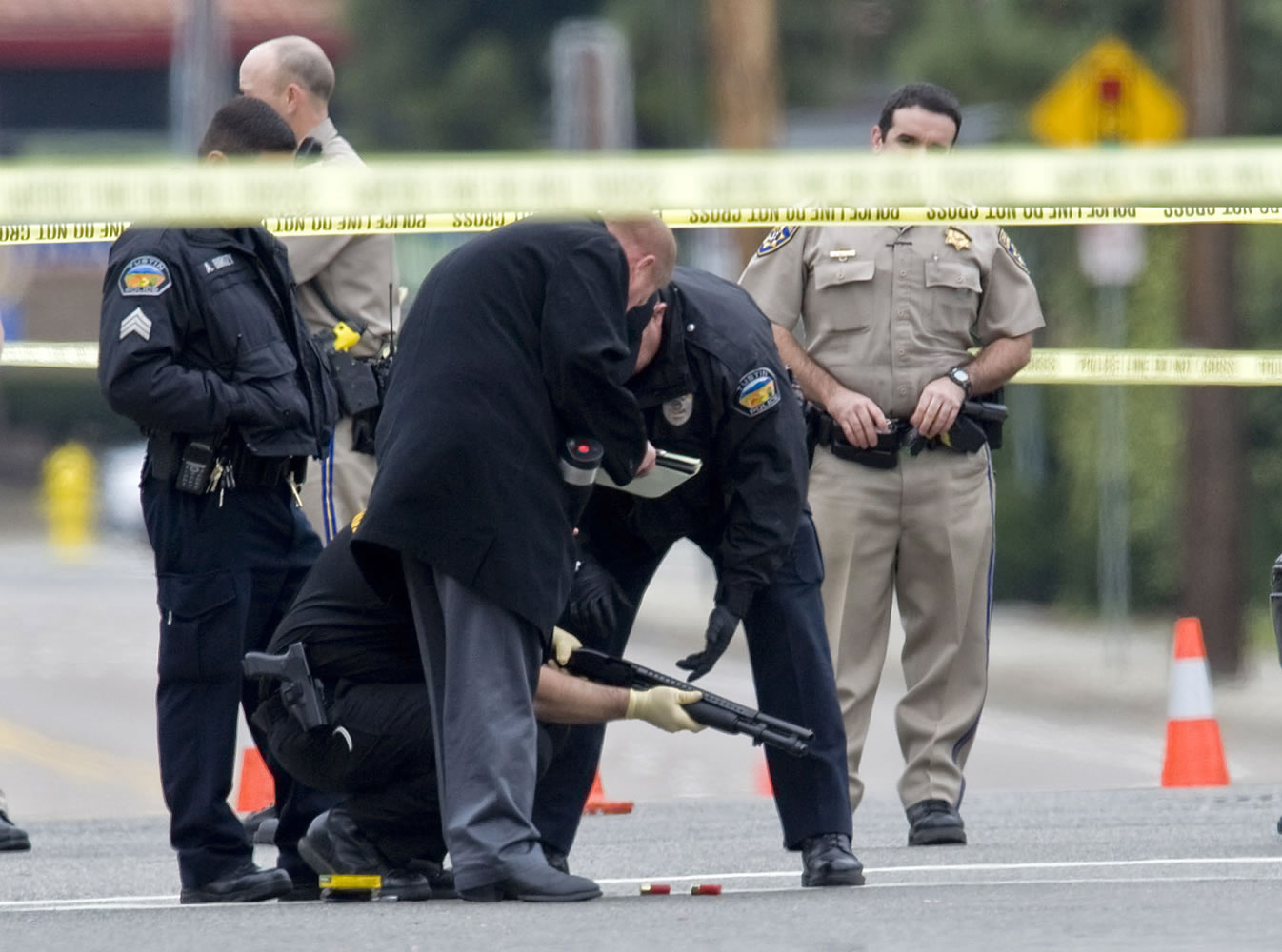 Police investigators examine the scene of a shooting early Tuesday.