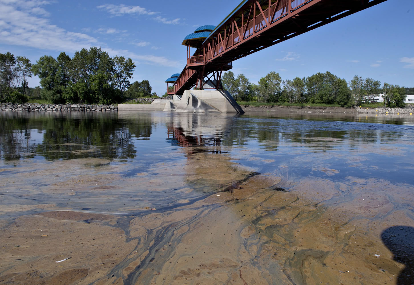 Traces of the oil spill that occurred following the runaway train derailment Saturday in Lac-Megantic, Quebec is seen about 46 miles downstream under a pedestrian bridge in the Chaudiere River at Saint-Georges, Quebec, on Monday.