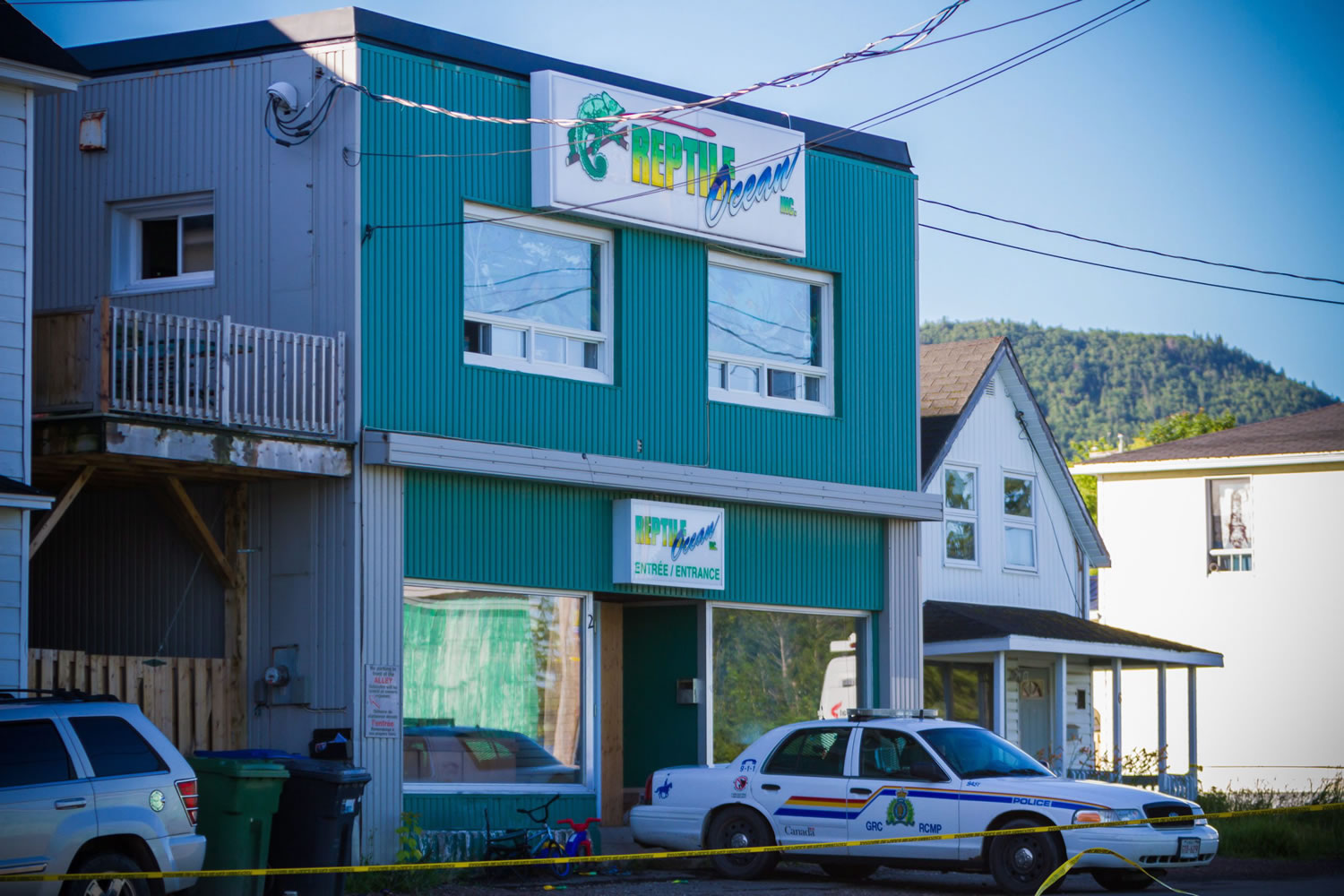 A Royal Canadian Mounted Police cruiser sits outside the Reptile Ocean exotic pet store Tuesday in Campbellton, New Brunswick, Canada, where two boys visiting the apartment above the store were killed by an African rock python.