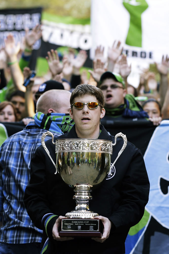 A member of the Emerald City Supporters carries the Cascadia Cup.