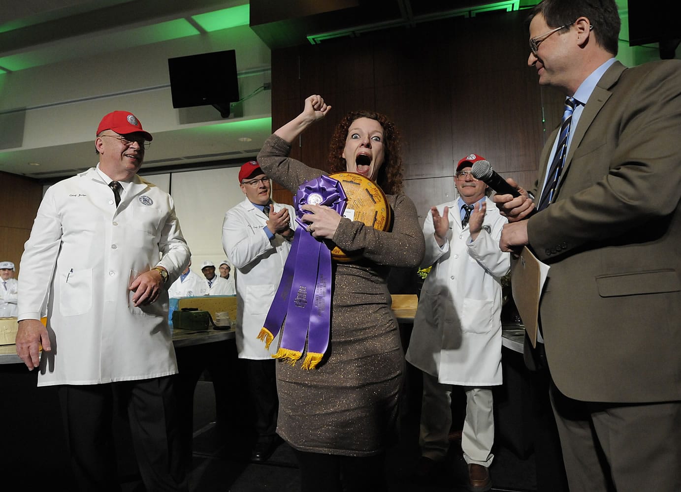 Marieke Penterman, center, owner of Holland's Family Cheese LLC in Thorp, Wis., reacts after winning first place in the U.S. Cheese Championship Contest at Lambeau Field in Green Bay, Wis., on Wednesday.