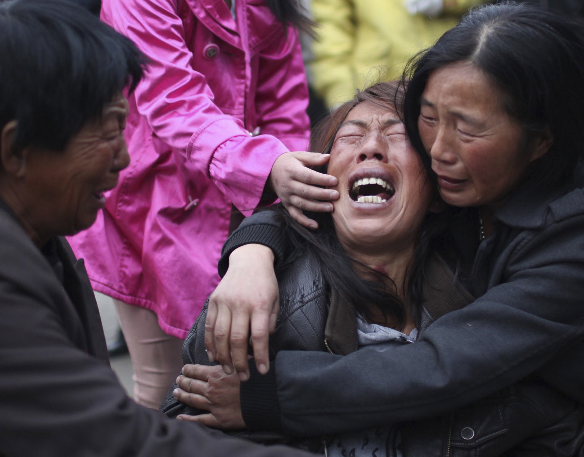 A family member of a worker cries near the accident site after a fire broke out at a poultry processing workshop on Monday in Mishazi Township in Dehui City, northeast China's Jilin Province.