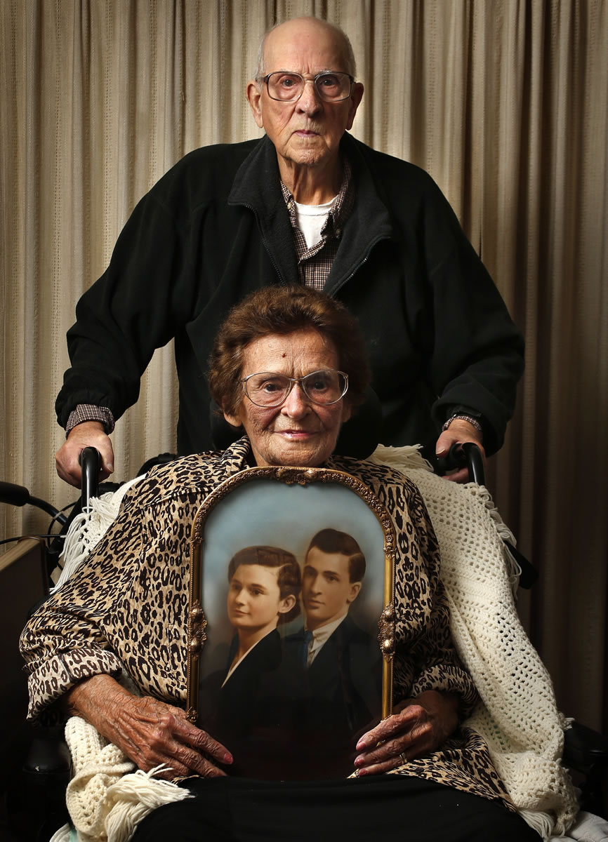 Dick Scharen holds the handles of his wife's chair as Velma Scharen holds their wedding portrait Sunday in Springfield, Ore. The photo was taken in the summer of 1938, six months into their marriage.