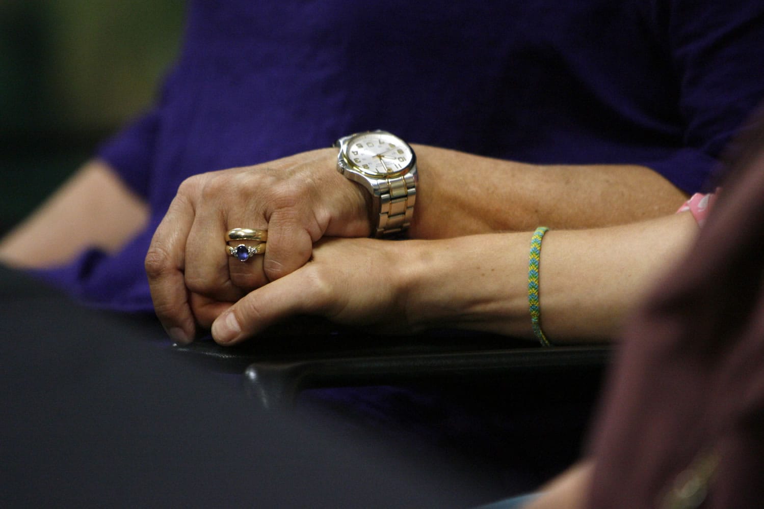 Tara Evans, left, hold the hand of her daughter Karen Evans during a news conference at the McKay-Dee Hospital Center in Ogden, Utah, on Monday to update the condition of Tara's husband, James Evans, who was shot in the head during church services on Sunday.