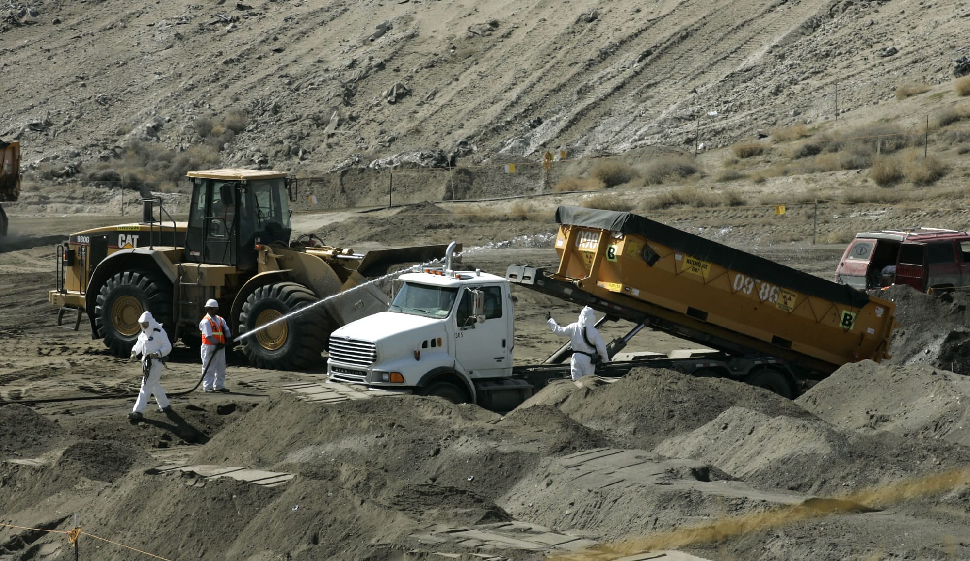 Workers wearing protective suits bury contaminated debris in a landfill on the Hanford nuclear reservation near Richland in 2008.