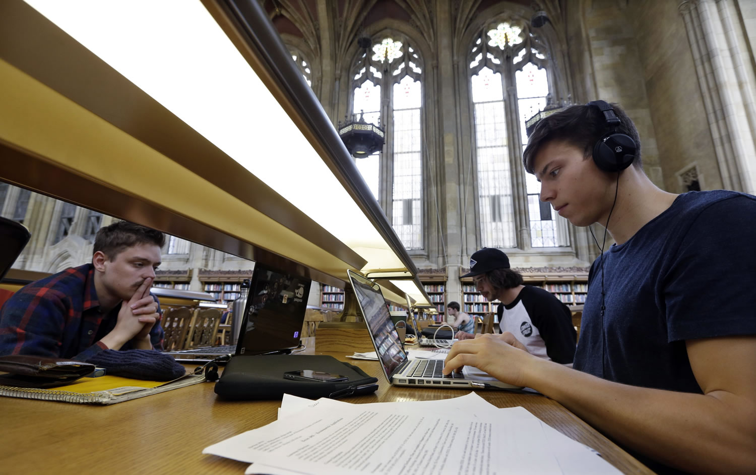 University of Washington students Benjamin Ferschli, left, Oscar Haavardsholm and Nicholas McMillan study April 26 in Suzzallo Library at the school in Seattle. Some of Washington's colleges and universities have been celebrating their decision not to raise tuition this fall, but they actually didn't have a choice.